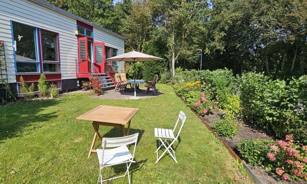 Side view of Glissando bungalow in Midsland North, Terschelling with green garden.