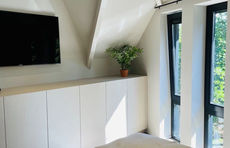 Lichte kamer met tv en uitzicht in vakantiehuisje in Ballum, Ameland.