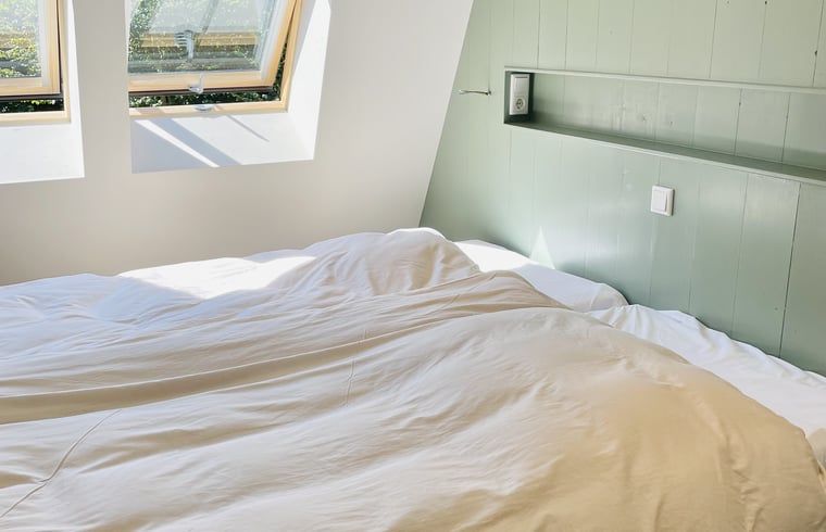 Gezellige slaapkamer met dakramen in vakantiehuisje in Ballum, Ameland.