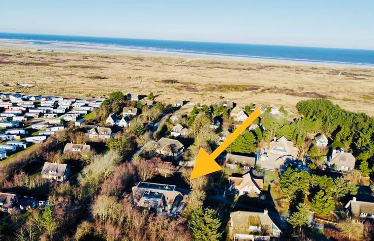 Luchtfoto van vakantiehuisje in Ballum, Ameland met nabijgelegen duinen.