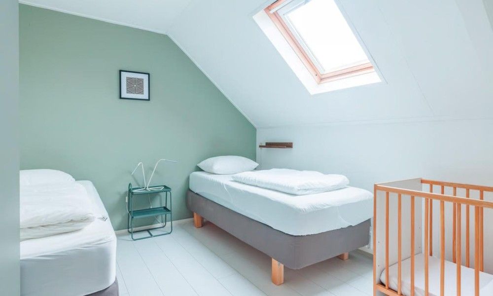Gezellige kinderkamer in Noorderzon, Buren, Ameland met comfortabele bedden en veel natuurlijk licht.