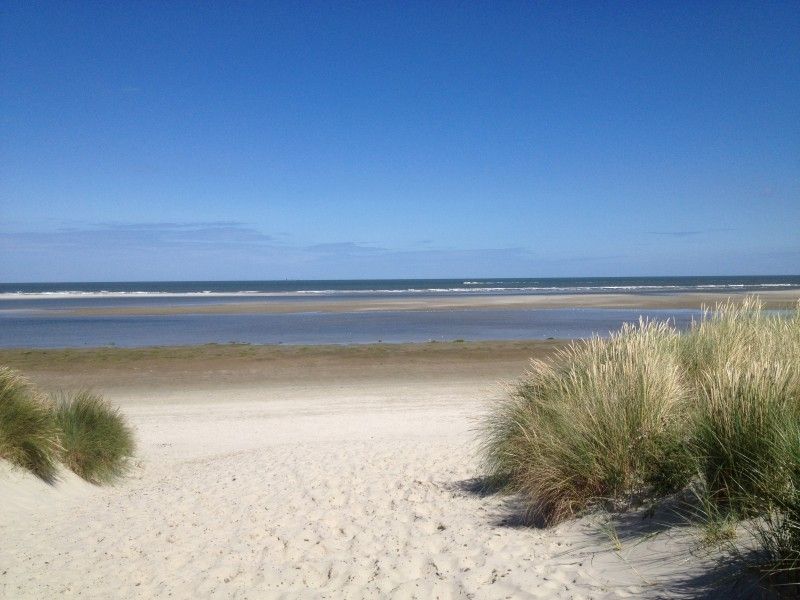 Uitzicht op het strand nabij Noorderzon, Buren, Ameland met uitgestrekte zandvlaktes en zee.