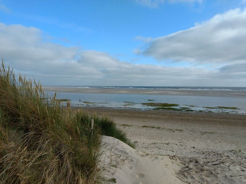 View of the beach and dunes near vacation home Naar Zee in Buren, Ameland.