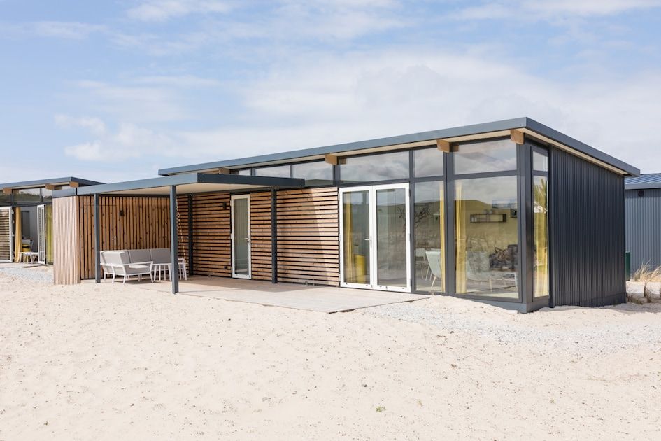 Das Ferienhaus Kooikers Comfort in Hollum, Ameland, bietet ein modernes Stranderlebnis auf den Watteninseln mit einer grossen Terrasse.