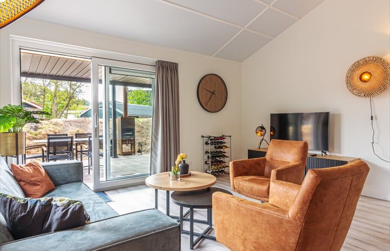 Gemuetliches Wohnzimmer im Ferienhaus in Nes, Ameland, mit Blick auf die Terrasse.