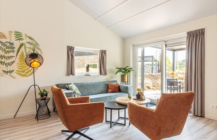 Heller Sitzbereich im Ferienhaus in Nes, Ameland, mit Zugang zur Terrasse.