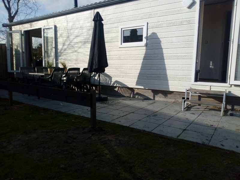 Sonnige Terrasse des Protter-Chalets in Buren, Ameland, ideal fr ein Frhstck im Freien auf den Watteninseln.