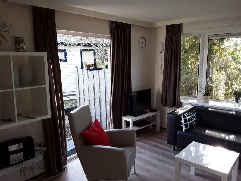 Helle Sitzecke im Ferienhaus Protter in Buren, Ameland, mit Blick auf die grne Umgebung.