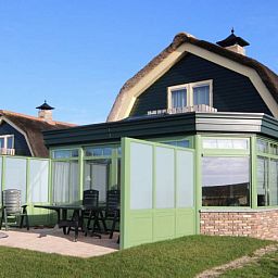 Terras van de 6 pers. luxe villa met serre in De Cocksdorp, Texel, perfect voor ontspanning op de Waddeneilanden.