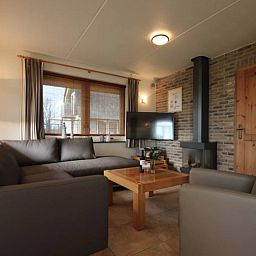 Comfortable living room in 6 pers. luxury wheelchair friendly villa, De Cocksdorp, Texel with sitting area and fireplace.