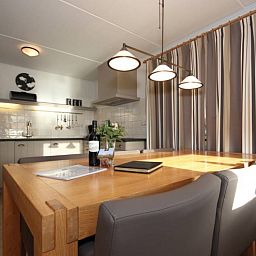 Dining area with wooden table in 6 pers. luxury wheelchair friendly villa, De Cocksdorp, Texel with lots of light.