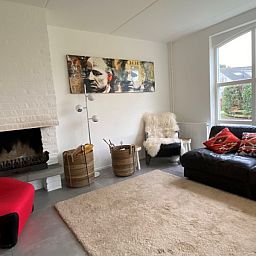 Gezellige woonkamer met open haard in Designhuis Volledig Vrij, een bungalow in De Cocksdorp, Texel.