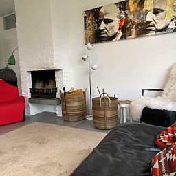 Sfeervolle zithoek in Designhuis Volledig Vrij bungalow, De Cocksdorp, Texel, met kunst aan de muur.