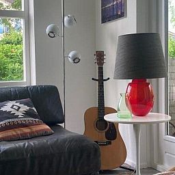 Comfortabele bank en gitaar in Designhuis Volledig Vrij bungalow, De Cocksdorp, Texel.