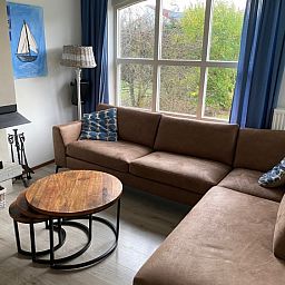 Gemuetliches Wohnzimmer in Krim 661 mit Sauna, Stuha und Grill, ein Bungalow in De Cocksdorp, Texel. Bequeme Sitzecke mit Blick auf die Natur.