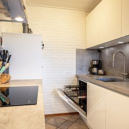 Praktische Kueche im Ferienhaus Schelpenoord 129, De Cocksdorp, Texel mit Spuelmaschine und Kochfeld.