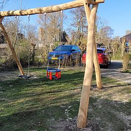 Speelterrein met schommel bij Het Eiland Gevoel, een vakantiehuis in De Cocksdorp op Texel, omringd door natuur en rust.
