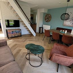 Gezellige woonkamer in vakantiehuis Het Eiland Gevoel, De Cocksdorp, Texel met comfortabele zitruimte en moderne inrichting.