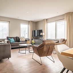 Gemuetliches Wohnzimmer des Ferienhauses Typ B-12 Hodshonstraat in De Cocksdorp, Texel, mit komfortabler Sitzecke.