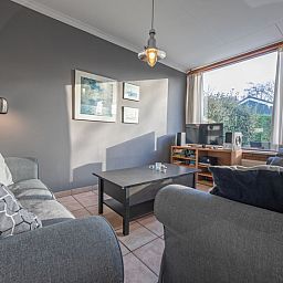 Helles Wohnzimmer mit Blick auf den Garten im Ferienhaus Slufterhoek 114, Texel.