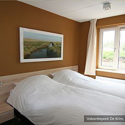 Lichte slaapkamer met uitzicht in Familievilla 10 persoons, De Cocksdorp, Texel.