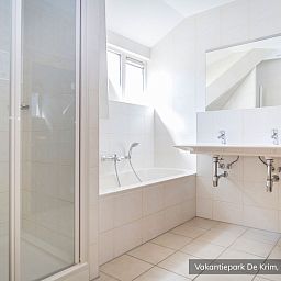 Ruime badkamer met douche en bad in Familievilla 10 persoons, De Cocksdorp, Texel.