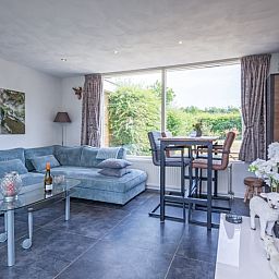 Cozy living room in Bungalow Duin aan Zee Texel, Bungalowpark Tamarisk, overlooking the green surroundings of De Cocksdorp.