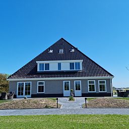 Vorderseite des Ferienhauses De Slufter in De Cocksdorp Texel, mit grossen Terrassen und Natur.