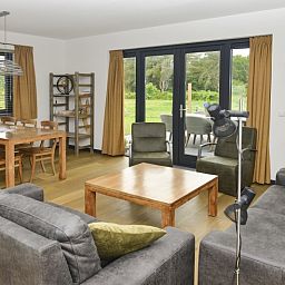 Gemuetliche Sitzecke im Ferienhaus De Postschipper auf Texel mit grossen Fenstern.