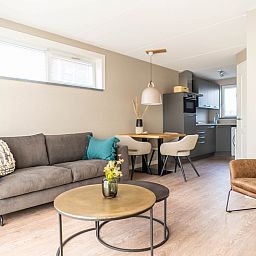 Cozy sitting area and kitchen in vacation home Type D Kikkertstraat, De Cocksdorp, Texel, for a relaxing stay.