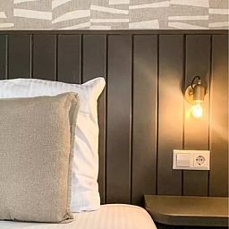 Schoenes Schlafzimmer im Ferienhaus Hogezandskil, De Cocksdorp, Texel mit moderner Beleuchtung und bequemem Bett.