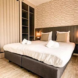 Luxurioeses Doppelbett im Ferienhaus Hogezandskil, De Cocksdorp, Texel mit stilvoller Einrichtung und weicher Bettwaesche.