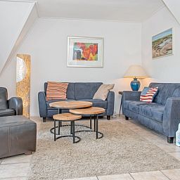 Gemuetliches Wohnzimmer im Ferienhaus Slufterduin 076, De Cocksdorp, Texel, mit bequemen Sofas zum Entspannen auf den Watteninseln.