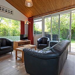 Helles Wohnzimmer des Ferienhauses Slufterduin 128 in De Cocksdorp, Texel mit Gartenblick.