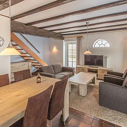 Gezellige woonkamer in Type T-4 vakantiehuis, De Cocksdorp, Texel met houten balken.