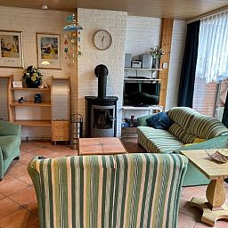 Gemuetliches Wohnzimmer des Ferienhauses Slufterhoek 128 in De Cocksdorp Texel mit bequemen Sitzgelegenheiten.
