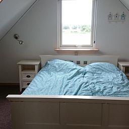 Attraktives Schlafzimmer im Vuurtorenweg 58 C Ferienhaus De Cocksdorp Texel mit Blick auf die Umgebung.