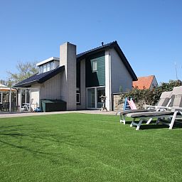 Geraeumiger Garten mit Liegestuehlen im Ferienhaus Blom & Co in De Cocksdorp, Texel.