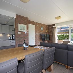 Ruime eetkamer in Bungalow De Witte Hoek 6 Pers., De Cocksdorp, Texel met moderne keuken en grote eettafel.