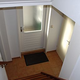 Entrance to Kikkertstraat 067, De Cocksdorp, Texel with stairs and tiled floor.