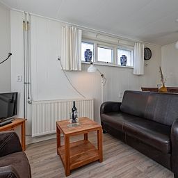Gemuetliches Wohnzimmer des Ferienhauses Kikkertstraat 60, De Cocksdorp, Texel mit komfortabler Sitzecke.
