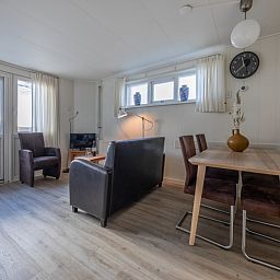 Helles Interieur des Ferienhauses Kikkertstraat 60, De Cocksdorp, Texel mit Ess- und Sitzecke.