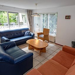 Helle Sitzecke im Ferienhaus Slufterduin 098, De Cocksdorp, Texel, mit Gartenblick und bequemen Sitzgelegenheiten.