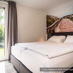 Schlafzimmer im Chalet Typ Vuurtoren de Luxe, De Cocksdorp, Texel mit bequemem Doppelbett.