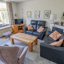 Gemuetliches Wohnzimmer des Ferienhauses Slufterhoek 078, Texel, mit bequemen Sofas und viel Licht.
