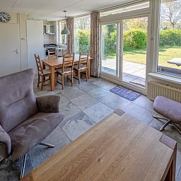 Ess- und Wohnbereich des Ferienhauses Slufterhoek 078, Texel, mit Blick in den Garten.