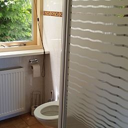 Modernes Badezimmer im Ferienhaus Ganzenvlucht, De Cocksdorp, Texel, mit grossen Fenstern und natuerlichem Licht.