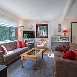 Gemuetliches Wohnzimmer des Ferienhauses Slufterduin 092 in De Cocksdorp, Texel mit bequemen Sofas.