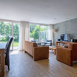 Helles Wohnzimmer im Ferienhaus Slufterhoek 132, Texel, mit grossen Fenstern und Blick auf die Natur