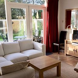 Helles Wohnzimmer im Ferienhaus Slufteroord 270, De Cocksdorp Texel, mit Zugang zur Terrasse und modernen Annehmlichkeiten.